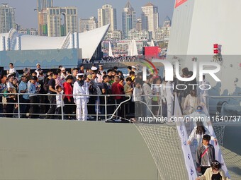 Tourists visit a warship at the port of the International Sailing Center in Qingdao, China, on October 3, 2024. (