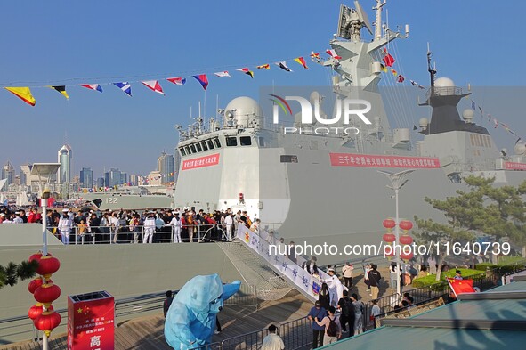 Tourists visit a warship at the port of the International Sailing Center in Qingdao, China, on October 3, 2024. 