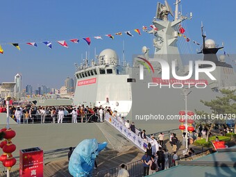 Tourists visit a warship at the port of the International Sailing Center in Qingdao, China, on October 3, 2024. (