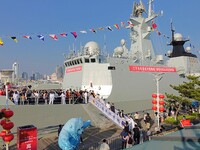 Tourists visit a warship at the port of the International Sailing Center in Qingdao, China, on October 3, 2024. (