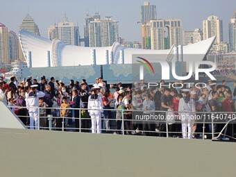 Tourists visit a warship at the port of the International Sailing Center in Qingdao, China, on October 3, 2024. (