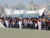 Tourists visit a warship at the port of the International Sailing Center in Qingdao, China, on October 3, 2024. (