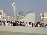 Tourists visit a warship at the port of the International Sailing Center in Qingdao, China, on October 3, 2024. (