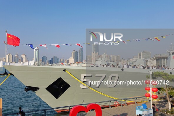 Tourists visit a warship at the port of the International Sailing Center in Qingdao, China, on October 3, 2024. 