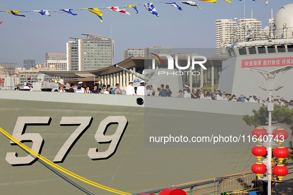 Tourists visit a warship at the port of the International Sailing Center in Qingdao, China, on October 3, 2024. 