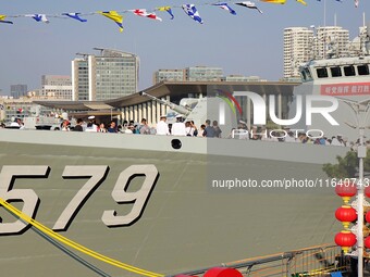 Tourists visit a warship at the port of the International Sailing Center in Qingdao, China, on October 3, 2024. (