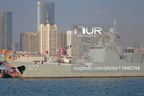 Tourists visit a warship at the port of the International Sailing Center in Qingdao, China, on October 3, 2024. 