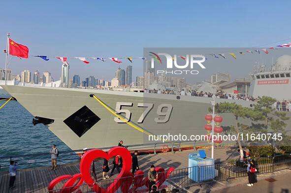 Tourists visit a warship at the port of the International Sailing Center in Qingdao, China, on October 3, 2024. 