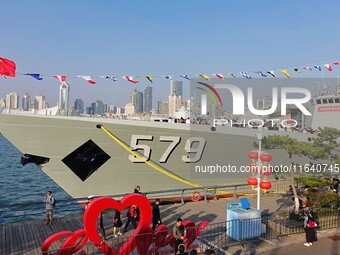 Tourists visit a warship at the port of the International Sailing Center in Qingdao, China, on October 3, 2024. (