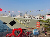 Tourists visit a warship at the port of the International Sailing Center in Qingdao, China, on October 3, 2024. (