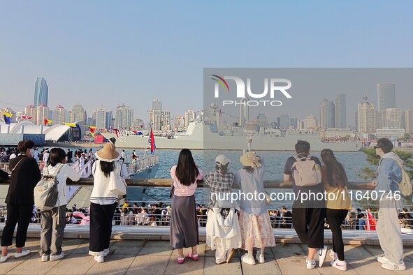 Tourists visit a warship at the port of the International Sailing Center in Qingdao, China, on October 3, 2024. 