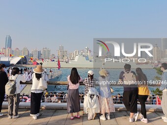 Tourists visit a warship at the port of the International Sailing Center in Qingdao, China, on October 3, 2024. (