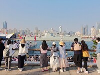 Tourists visit a warship at the port of the International Sailing Center in Qingdao, China, on October 3, 2024. (