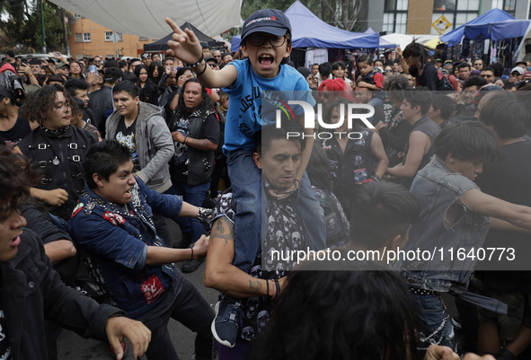 A young man carries his son during a concert to mark the 44th anniversary of the Tianguis Cultural del Chopo in Mexico City, Mexico, on Octo...