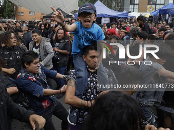 A young man carries his son during a concert to mark the 44th anniversary of the Tianguis Cultural del Chopo in Mexico City, Mexico, on Octo...