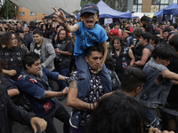 A young man carries his son during a concert to mark the 44th anniversary of the Tianguis Cultural del Chopo in Mexico City, Mexico, on Octo...