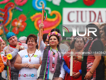 Incoming Mexico City Chief of Government Clara Brugada Molina receives the baton of command from representatives of indigenous peoples durin...