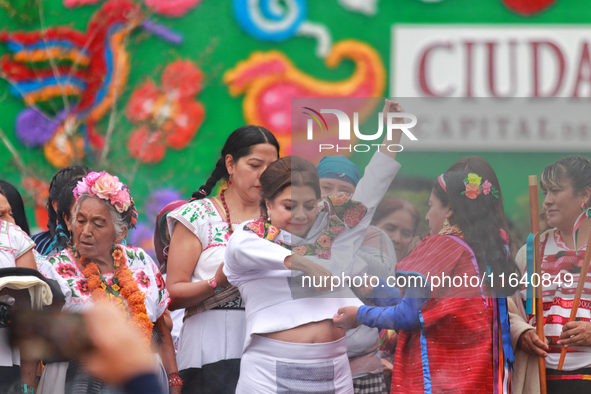 Incoming Mexico City Chief of Government Clara Brugada Molina receives the baton of command from representatives of indigenous peoples durin...