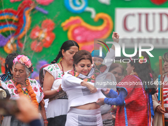 Incoming Mexico City Chief of Government Clara Brugada Molina receives the baton of command from representatives of indigenous peoples durin...