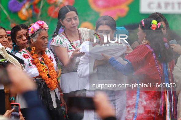 Incoming Mexico City Chief of Government Clara Brugada Molina receives the baton of command from representatives of indigenous peoples durin...