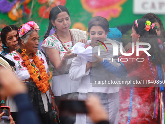 Incoming Mexico City Chief of Government Clara Brugada Molina receives the baton of command from representatives of indigenous peoples durin...