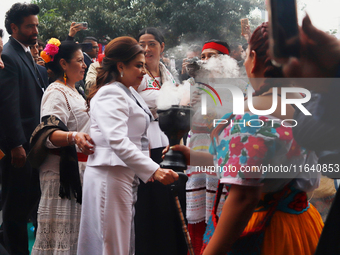 Incoming Mexico City Chief of Government Clara Brugada Molina receives the baton of command from representatives of indigenous peoples durin...