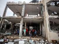 People inspect the damage to a mosque after it is hit in an Israeli strike in Deir al-Balah, central Gaza Strip, on October 6, 2024, amid th...