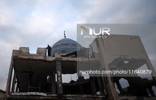 A Palestinian inspects the damage to a mosque after it is hit in an Israeli strike in Deir al-Balah, central Gaza Strip, on October 6, 2024,...