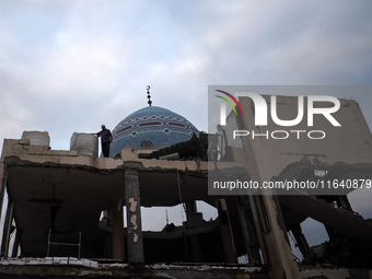 A Palestinian inspects the damage to a mosque after it is hit in an Israeli strike in Deir al-Balah, central Gaza Strip, on October 6, 2024,...