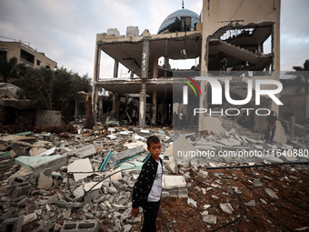 A Palestinian inspects the damage to a mosque after it is hit in an Israeli strike in Deir al-Balah, central Gaza Strip, on October 6, 2024,...