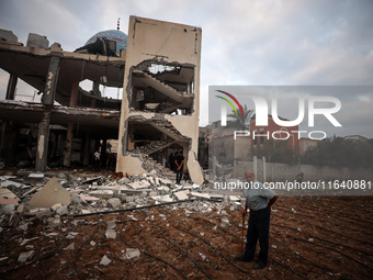 A Palestinian inspects the damage to a mosque after it is hit in an Israeli strike in Deir al-Balah, central Gaza Strip, on October 6, 2024,...