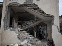 People inspect the damage to a mosque after it is hit in an Israeli strike in Deir al-Balah, central Gaza Strip, on October 6, 2024, amid th...