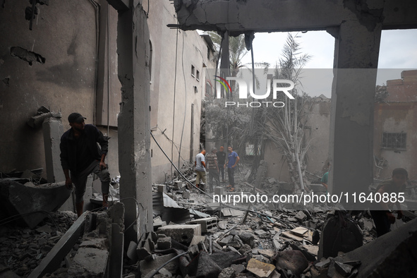 People inspect the damage to a mosque after it is hit in an Israeli strike in Deir al-Balah, central Gaza Strip, on October 6, 2024, amid th...