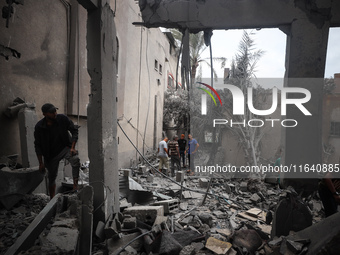 People inspect the damage to a mosque after it is hit in an Israeli strike in Deir al-Balah, central Gaza Strip, on October 6, 2024, amid th...