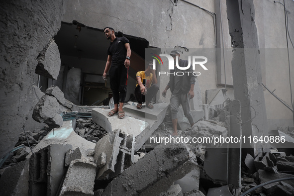 People inspect the damage to a mosque after it is hit in an Israeli strike in Deir al-Balah, central Gaza Strip, on October 6, 2024, amid th...