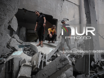 People inspect the damage to a mosque after it is hit in an Israeli strike in Deir al-Balah, central Gaza Strip, on October 6, 2024, amid th...