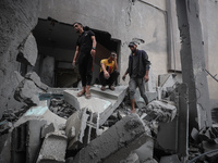 People inspect the damage to a mosque after it is hit in an Israeli strike in Deir al-Balah, central Gaza Strip, on October 6, 2024, amid th...