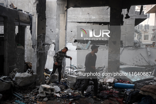 People inspect the damage to a mosque after it is hit in an Israeli strike in Deir al-Balah, central Gaza Strip, on October 6, 2024, amid th...