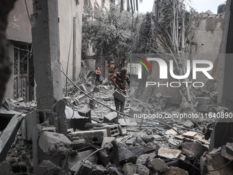 People inspect the damage to a mosque after it is hit in an Israeli strike in Deir al-Balah, central Gaza Strip, on October 6, 2024, amid th...