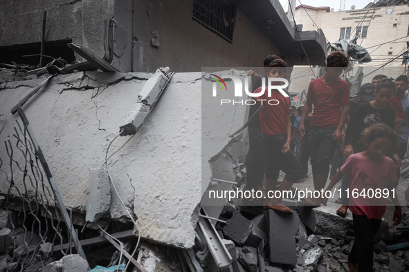 People inspect the damage to a mosque after it is hit in an Israeli strike in Deir al-Balah, central Gaza Strip, on October 6, 2024, amid th...