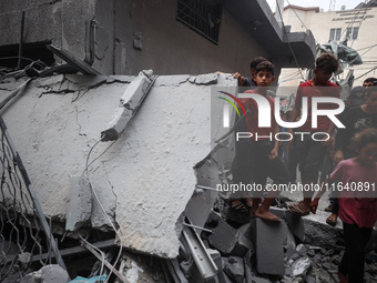 People inspect the damage to a mosque after it is hit in an Israeli strike in Deir al-Balah, central Gaza Strip, on October 6, 2024, amid th...