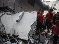 People inspect the damage to a mosque after it is hit in an Israeli strike in Deir al-Balah, central Gaza Strip, on October 6, 2024, amid th...