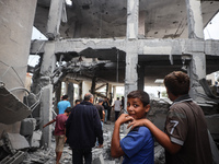 People inspect the damage to a mosque after it is hit in an Israeli strike in Deir al-Balah, central Gaza Strip, on October 6, 2024, amid th...