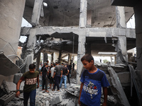 People inspect the damage to a mosque after it is hit in an Israeli strike in Deir al-Balah, central Gaza Strip, on October 6, 2024, amid th...