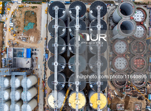 Workers work at the construction site of the first phase of the Hualian grain storage and logistics project at Huangma Port in Huaian City,...