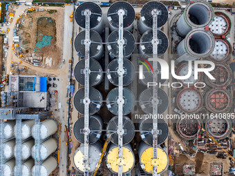 Workers work at the construction site of the first phase of the Hualian grain storage and logistics project at Huangma Port in Huaian City,...