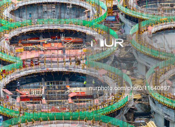 Workers work at the construction site of the first phase of the Hualian grain storage and logistics project at Huangma Port in Huaian City,...