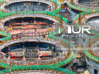 Workers work at the construction site of the first phase of the Hualian grain storage and logistics project at Huangma Port in Huaian City,...