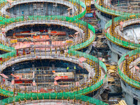 Workers work at the construction site of the first phase of the Hualian grain storage and logistics project at Huangma Port in Huaian City,...