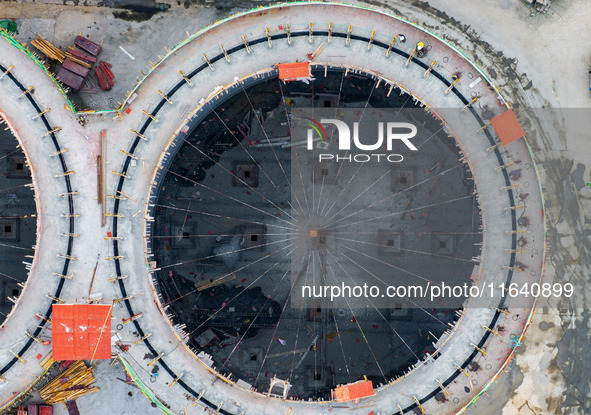 Workers work at the construction site of the first phase of the Hualian grain storage and logistics project at Huangma Port in Huaian City,...